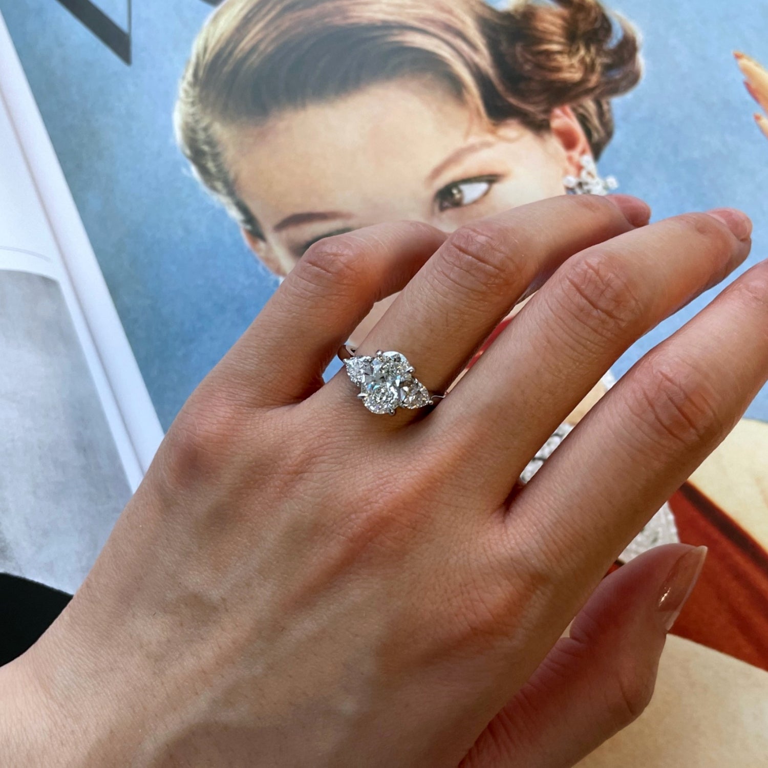 Oval and Heart-Shaped Diamond Three-Stone Engagement Ring on a Hand