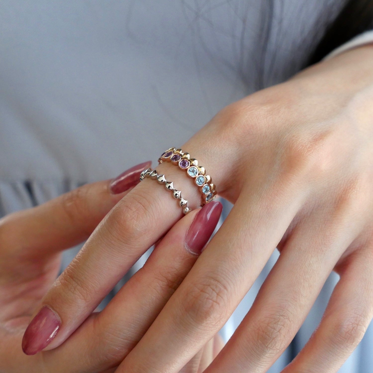 Mermaid Blue Topaz and Amethyst Eternity Ring on a Hand