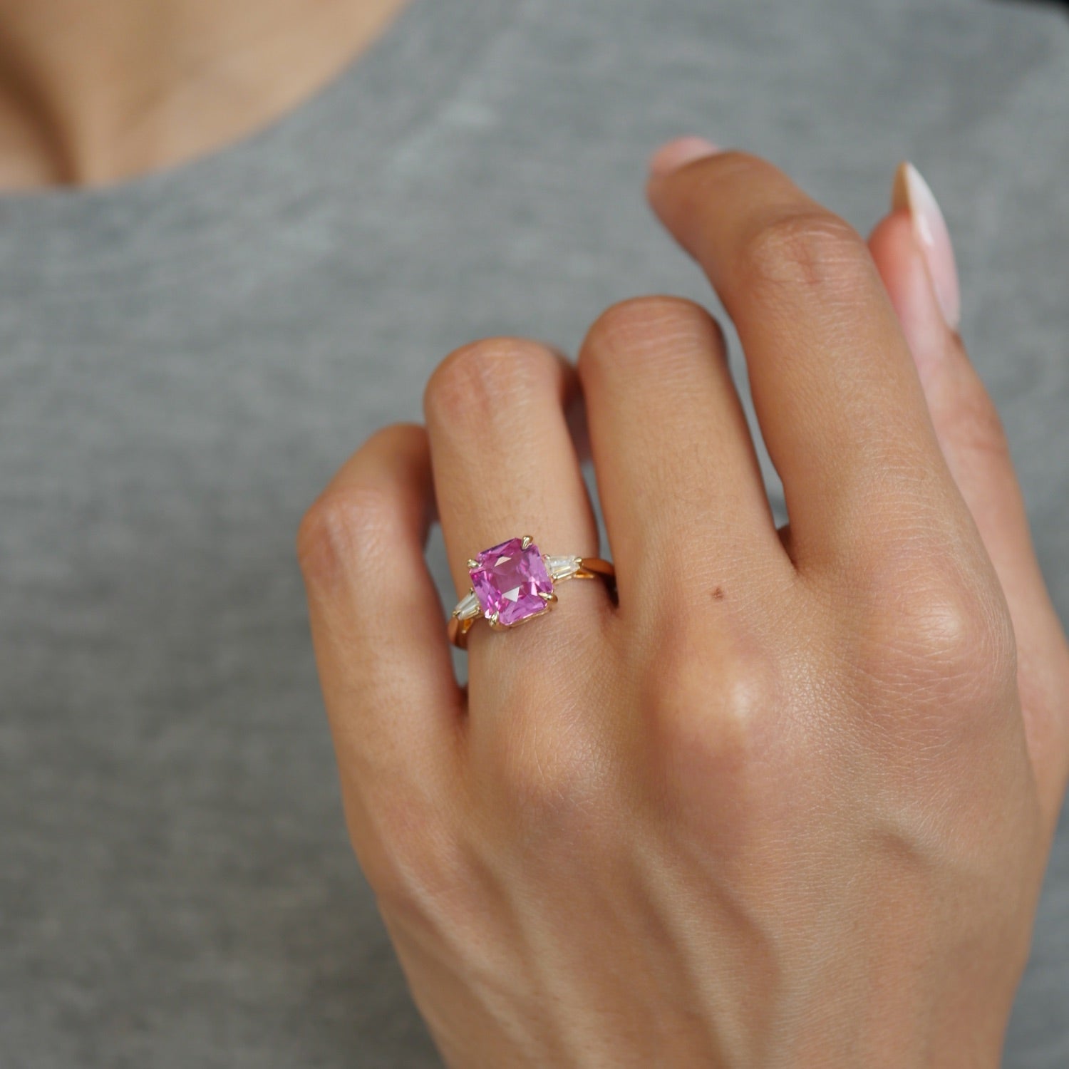 Cut Corner Square Scissor Cut Pink Sapphire and Tapered Baguette Diamond Three-Stone Ring on a Model