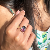 Close-up of a hand wearing a ring with a bicolour tourmaline and two side diamonds