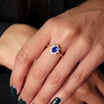 Oval-Shaped Blue Sapphire and Diamond Starburst Ring on a Model