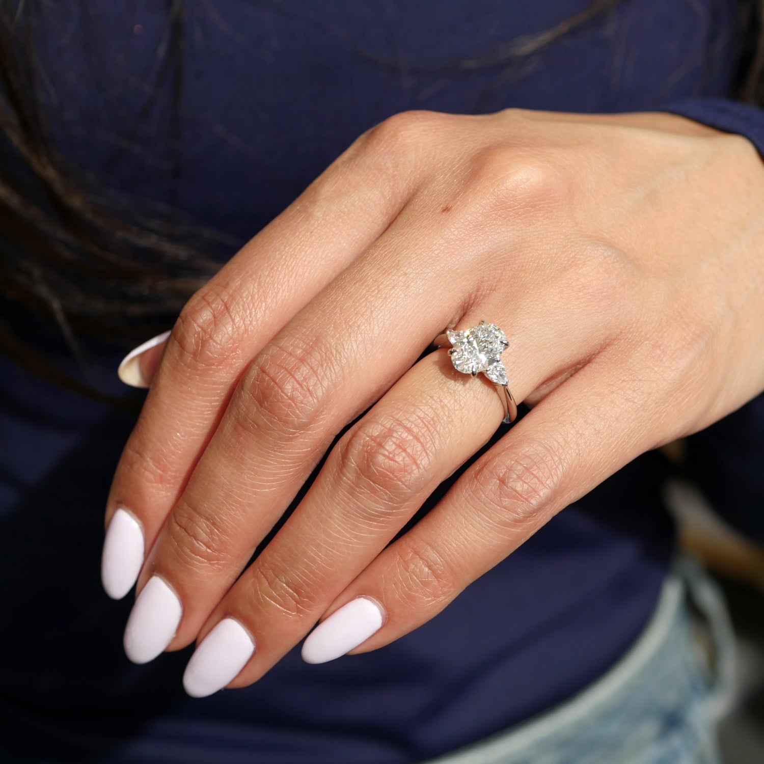Oval and Pear Cut Lab-Grown Diamond Three-Stone Engagement Ring on a Model