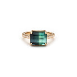 Emerald-cut blue tourmaline in an east-west setting on a diamond pavé band in 14K yellow gold.
