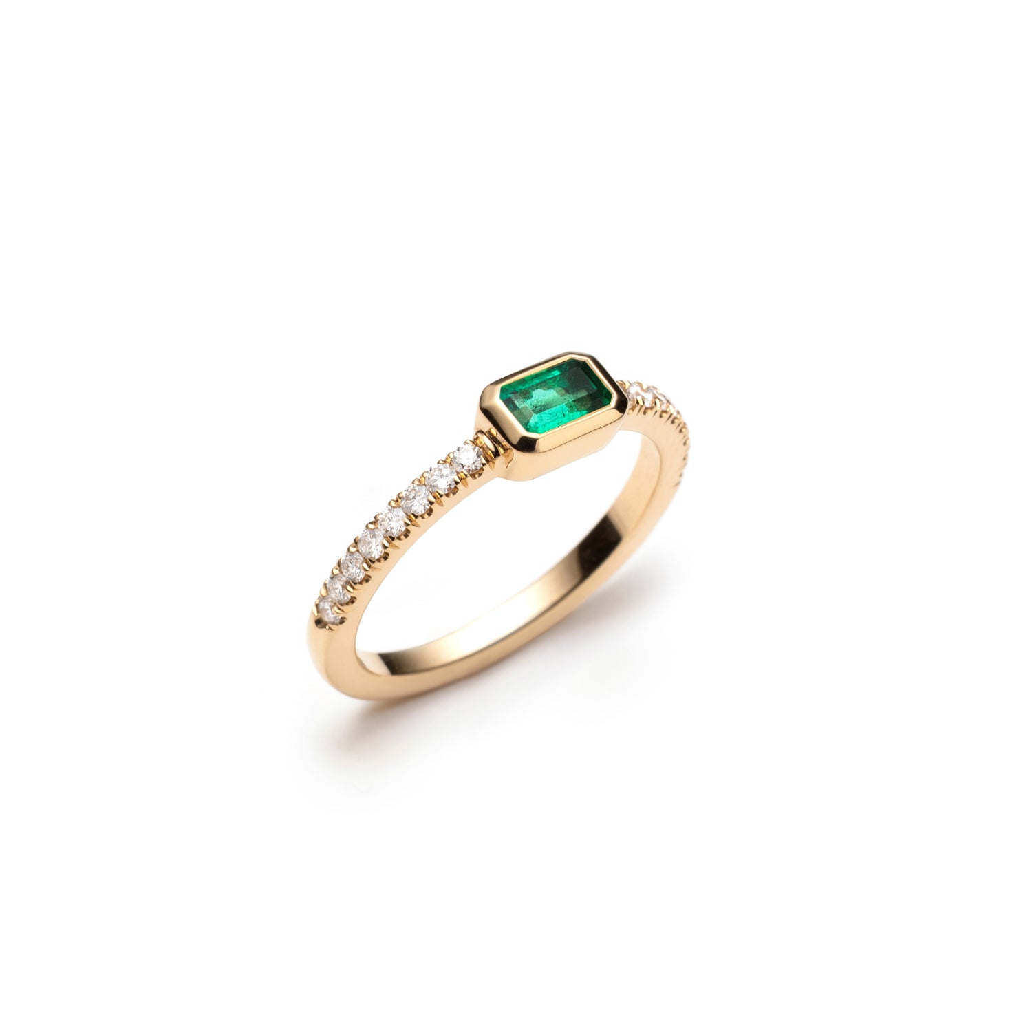 Side profile of an emerald-cut emerald and diamond pavé stackable ring, showing the gemstone setting and band.