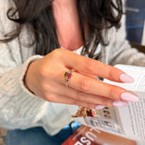 Emerald-cut watermelon tourmaline and diamond pavé three-stone ring, worn on a hand.