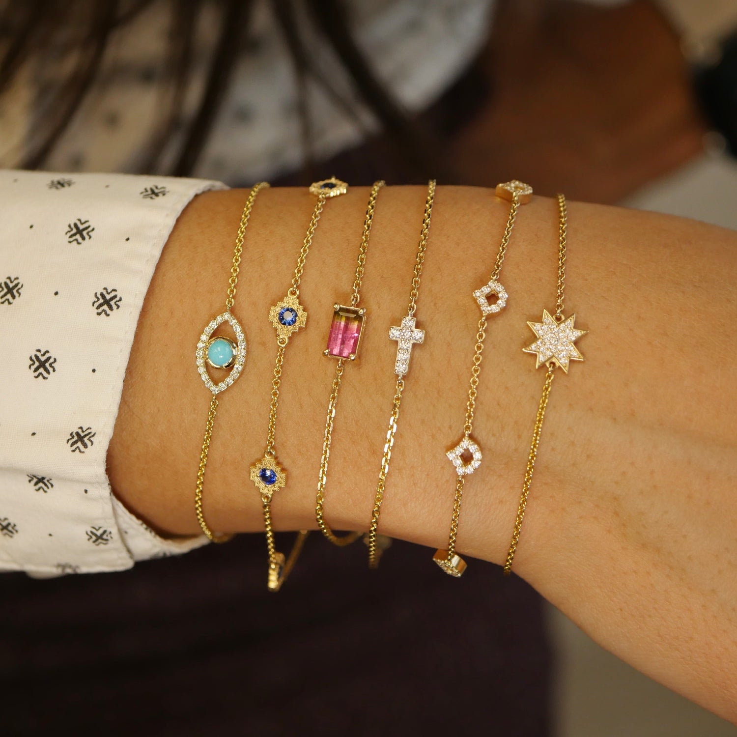 Lepi mermaid scale diamond pavé bracelet, turquoise and diamond pavé evil eye bracelet, and emerald cut watermelon tourmaline bracelet stacked on the wrist.