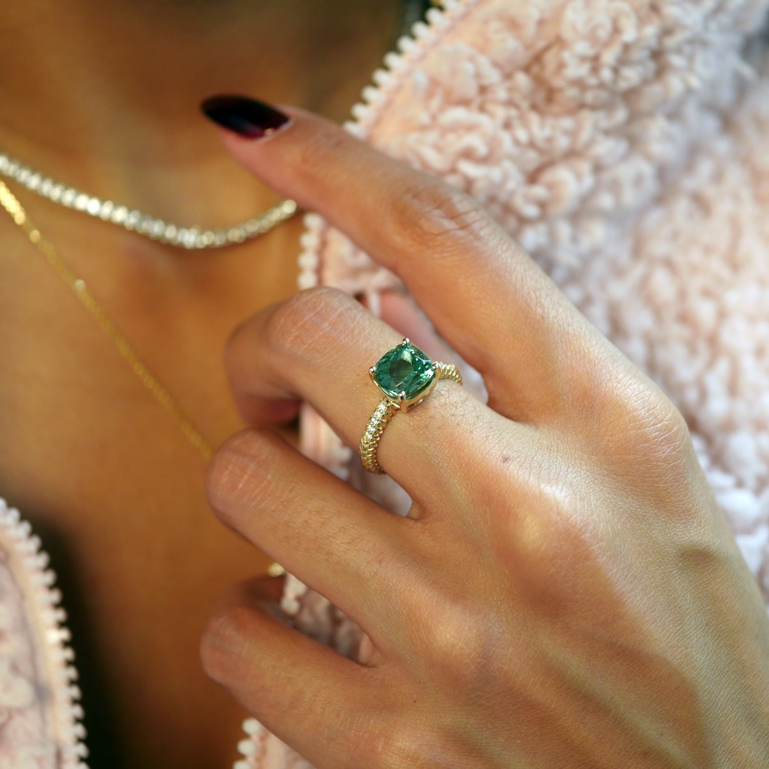 Lepia cushion-shaped green tourmaline ring in 14K yellow gold, worn on a hand.