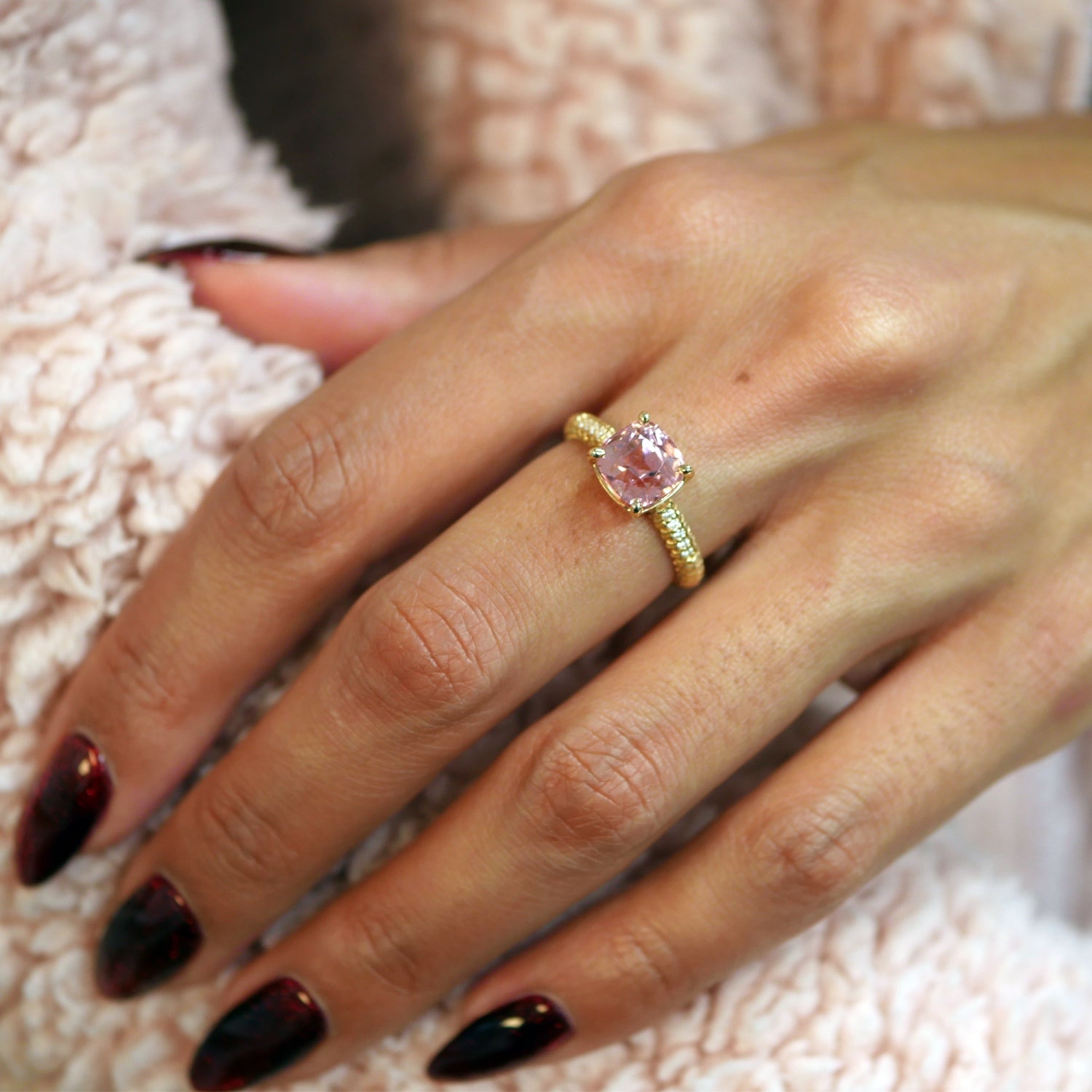 Lepia cushion-shaped pink tourmaline ring in 14K yellow gold, worn on a hand.