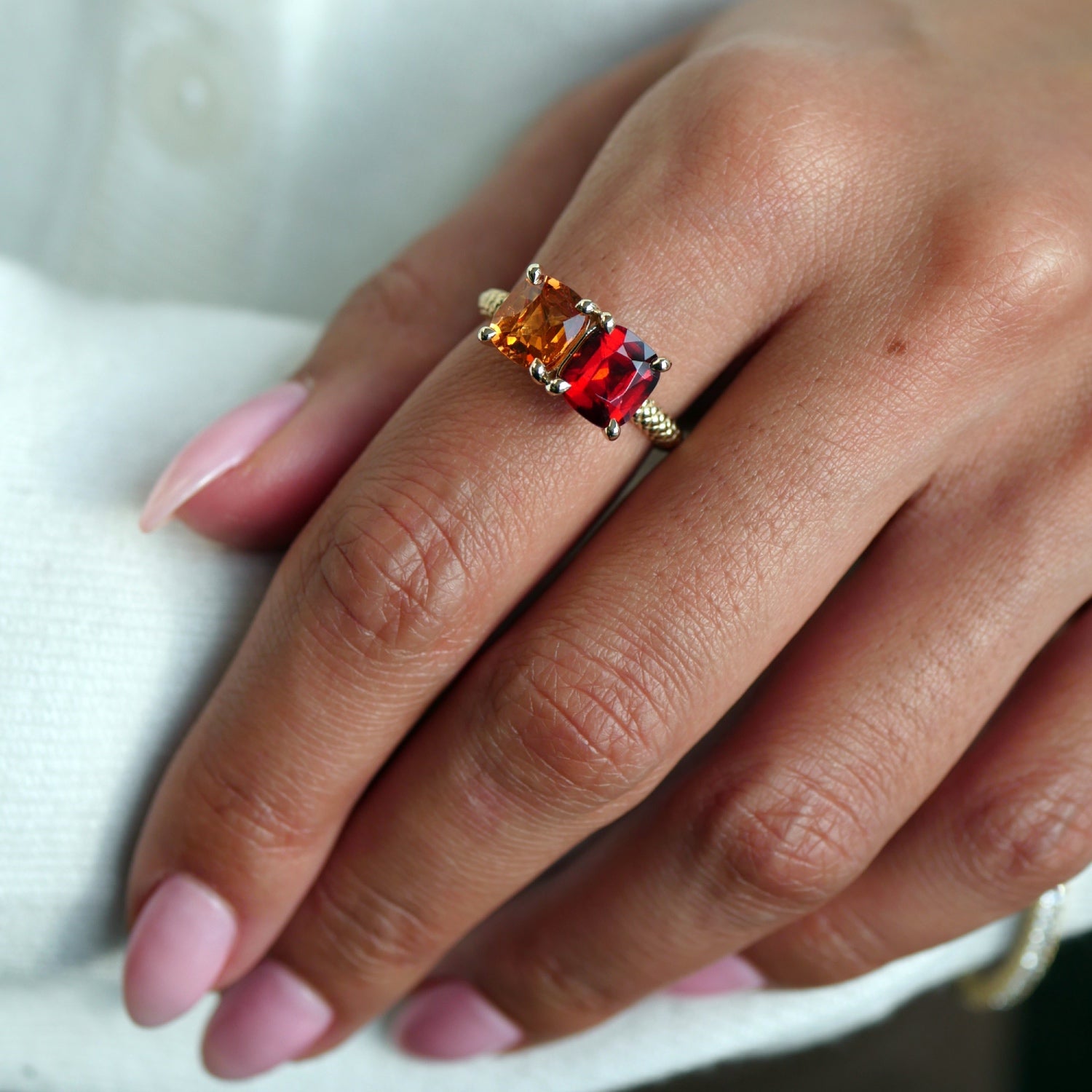 Lepia orange and red garnet Toi et Moi ring in 14K yellow gold, worn on a hand.
