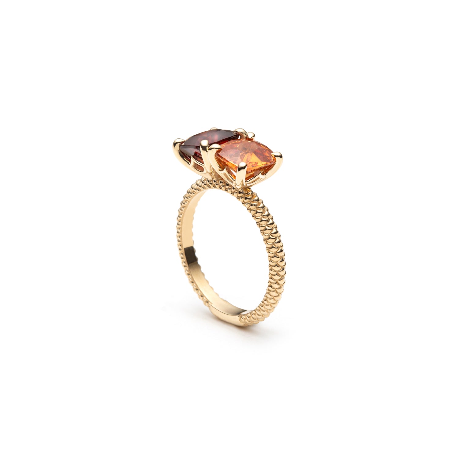 Side view of the Lepia orange and red garnet Toi et Moi ring, showing the prong settings and mermaid scale motif on the yellow gold band.