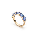 Angled side view of the Lepia five-stone blue sapphire ring, showing the prong settings and mermaid scale motif on the 14K yellow gold band.