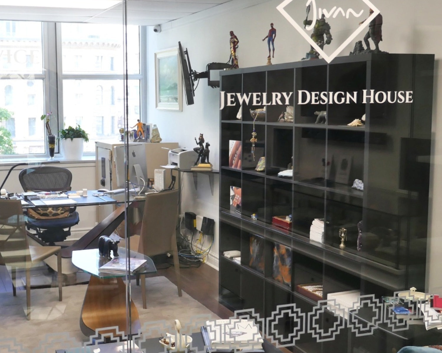 Interior of the Jewelry Design House atelier in Montreal, viewed through a glass partition with the brand’s logo.