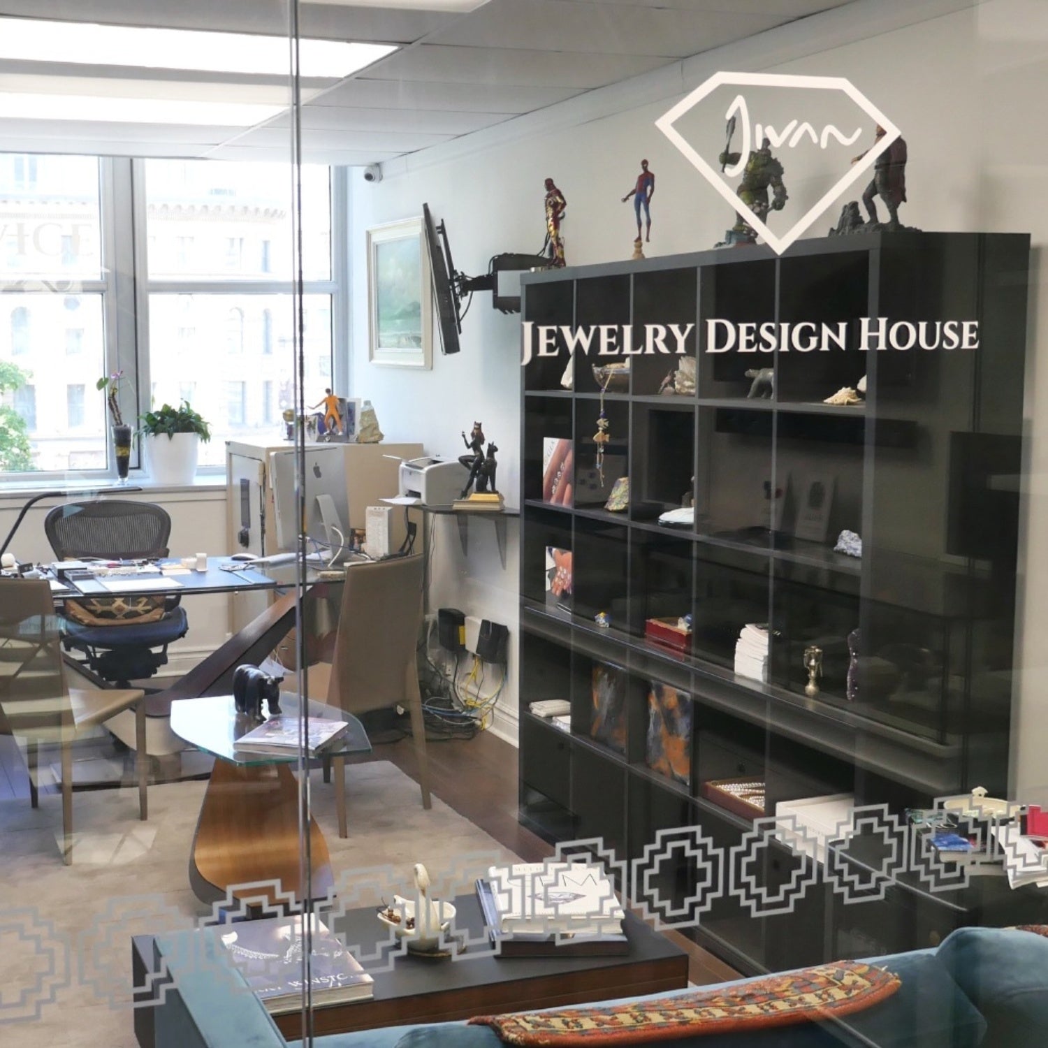 Interior of the Jewelry Design House atelier in Montreal, viewed through a glass partition with the brand’s logo.