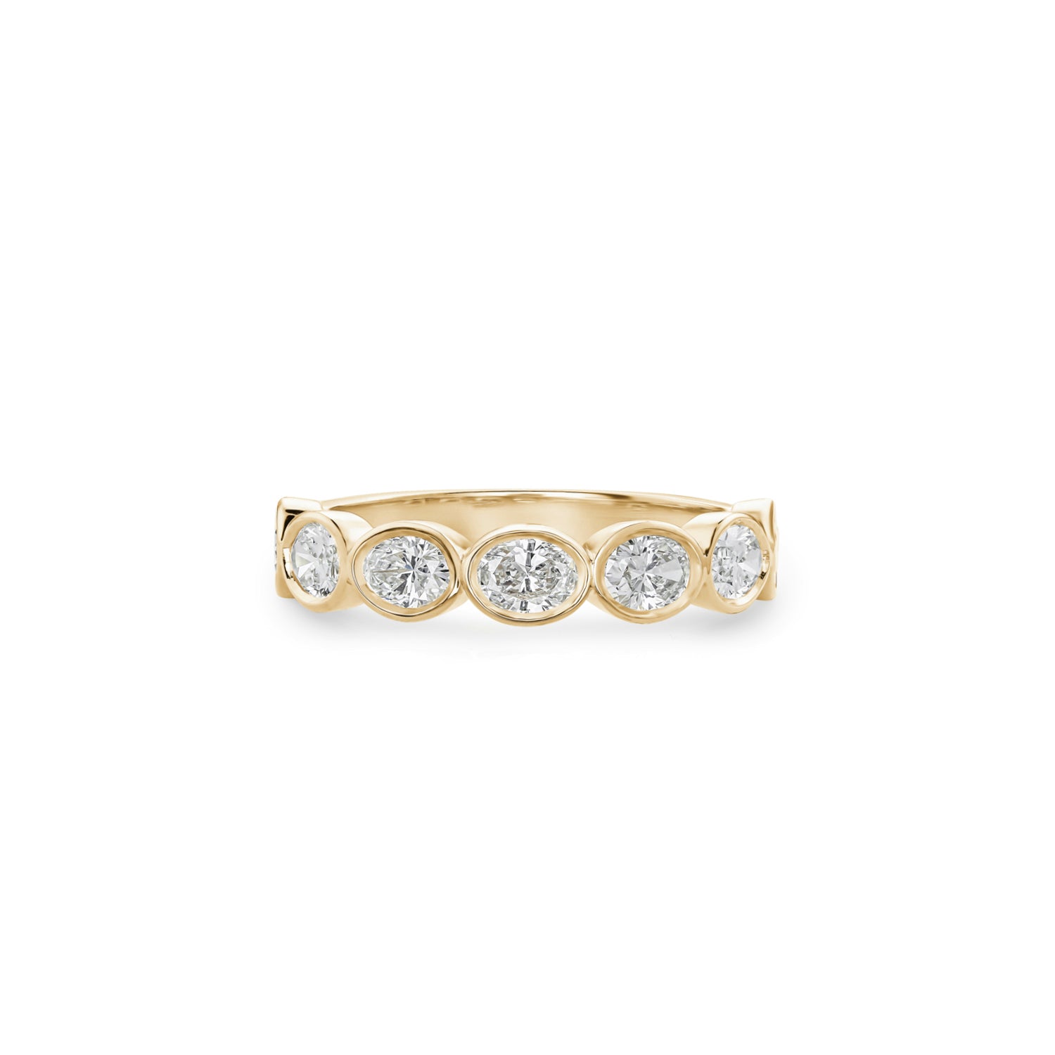 Oval-shaped lab-grown diamonds in yellow gold bezel settings across a half-eternity ring.