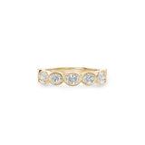 Oval-shaped lab-grown diamonds in yellow gold bezel settings across a half-eternity ring.