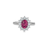 Oval-shaped pink sapphire surrounded by round brilliant-cut diamonds in a platinum cluster ring.