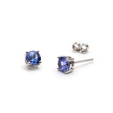 Round cut blue tanzanite stud earrings set in a classic four-prong basket setting in white gold