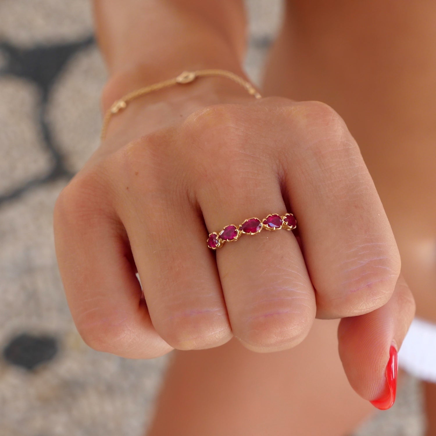 Lepia Pear-Shaped Ruby Five-Stone Ring on a Hand